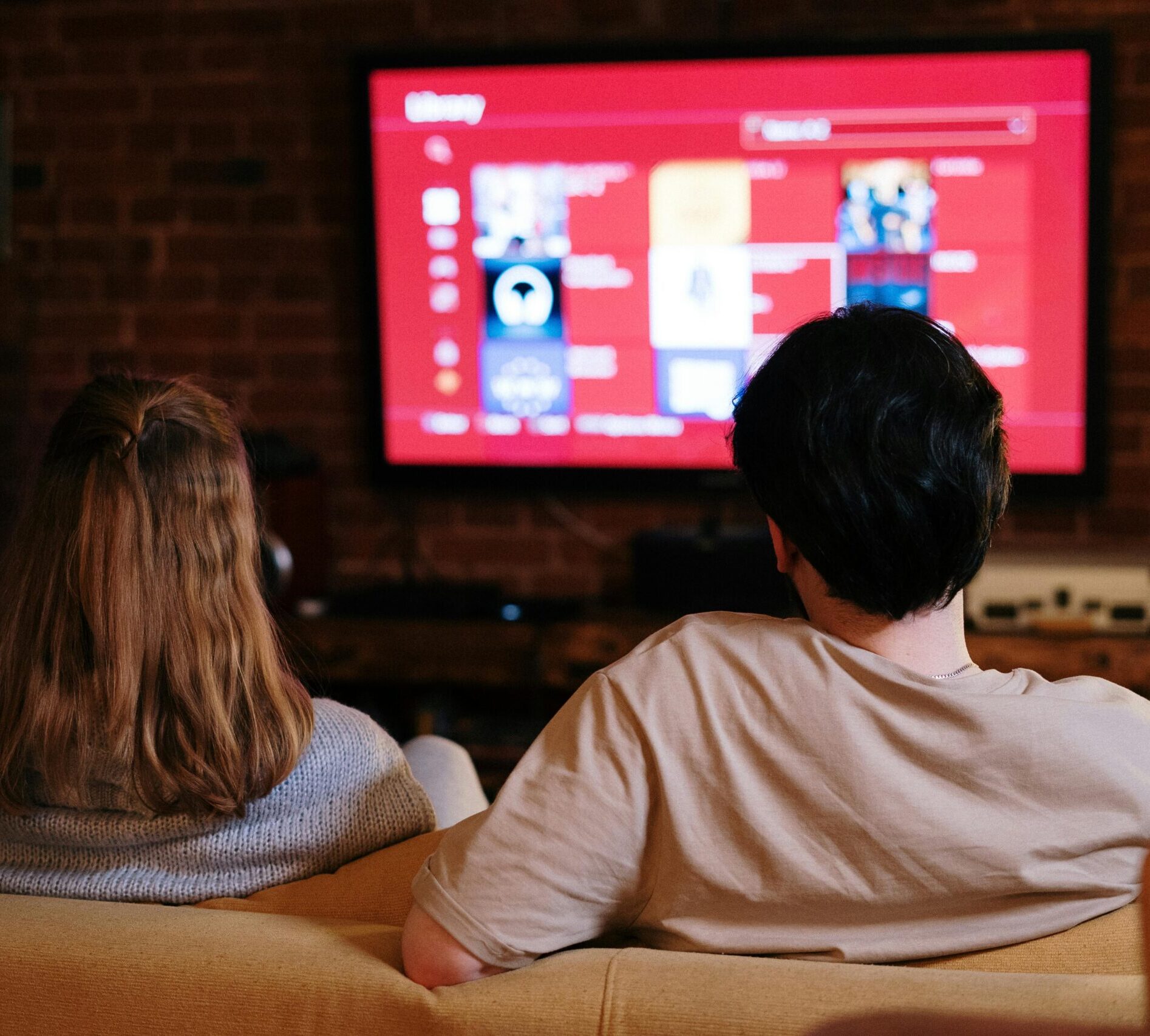 Two people sitting in front of t.v